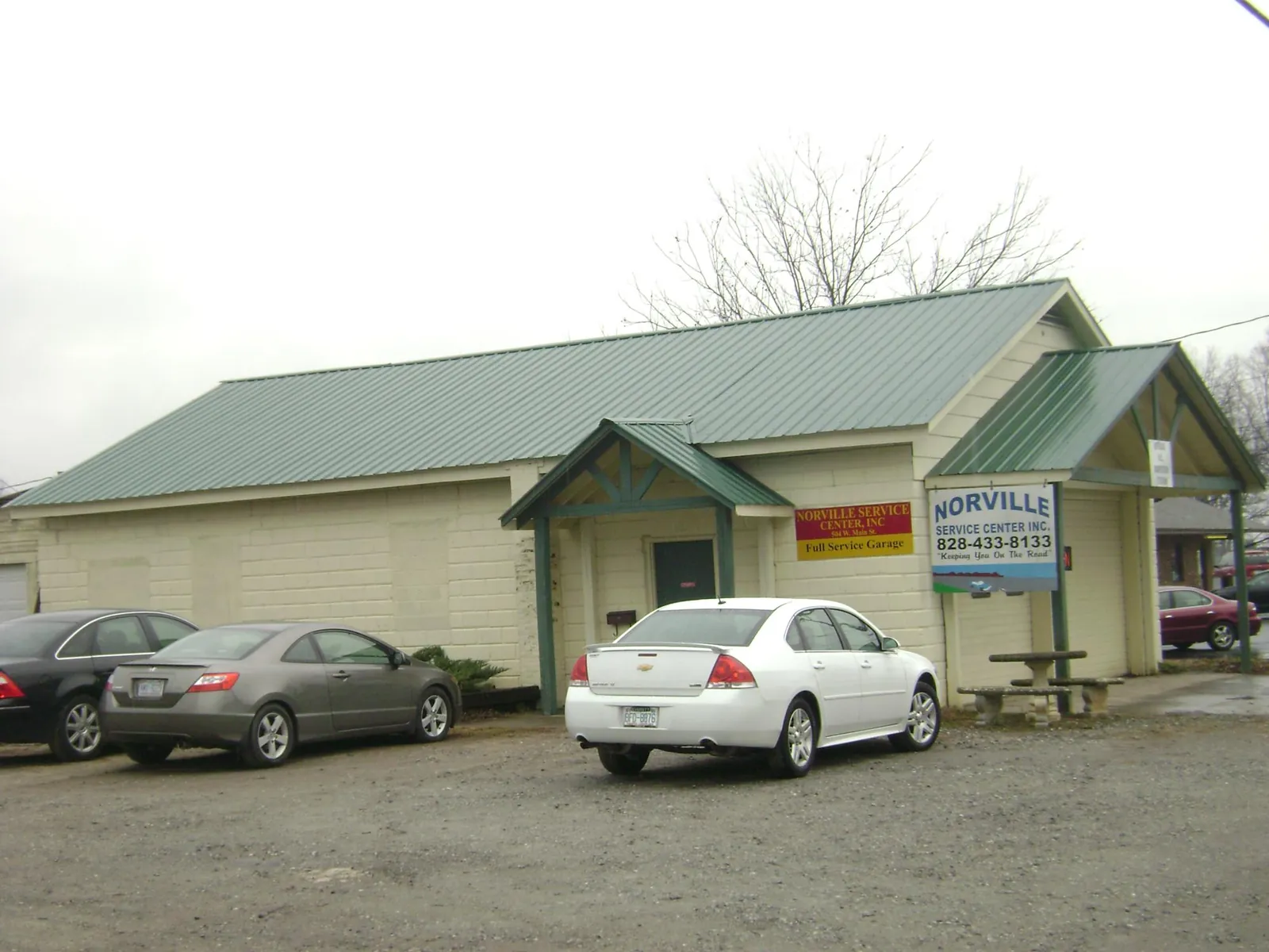Green metal roof on a service garage with a covered entry in Bear Creek
