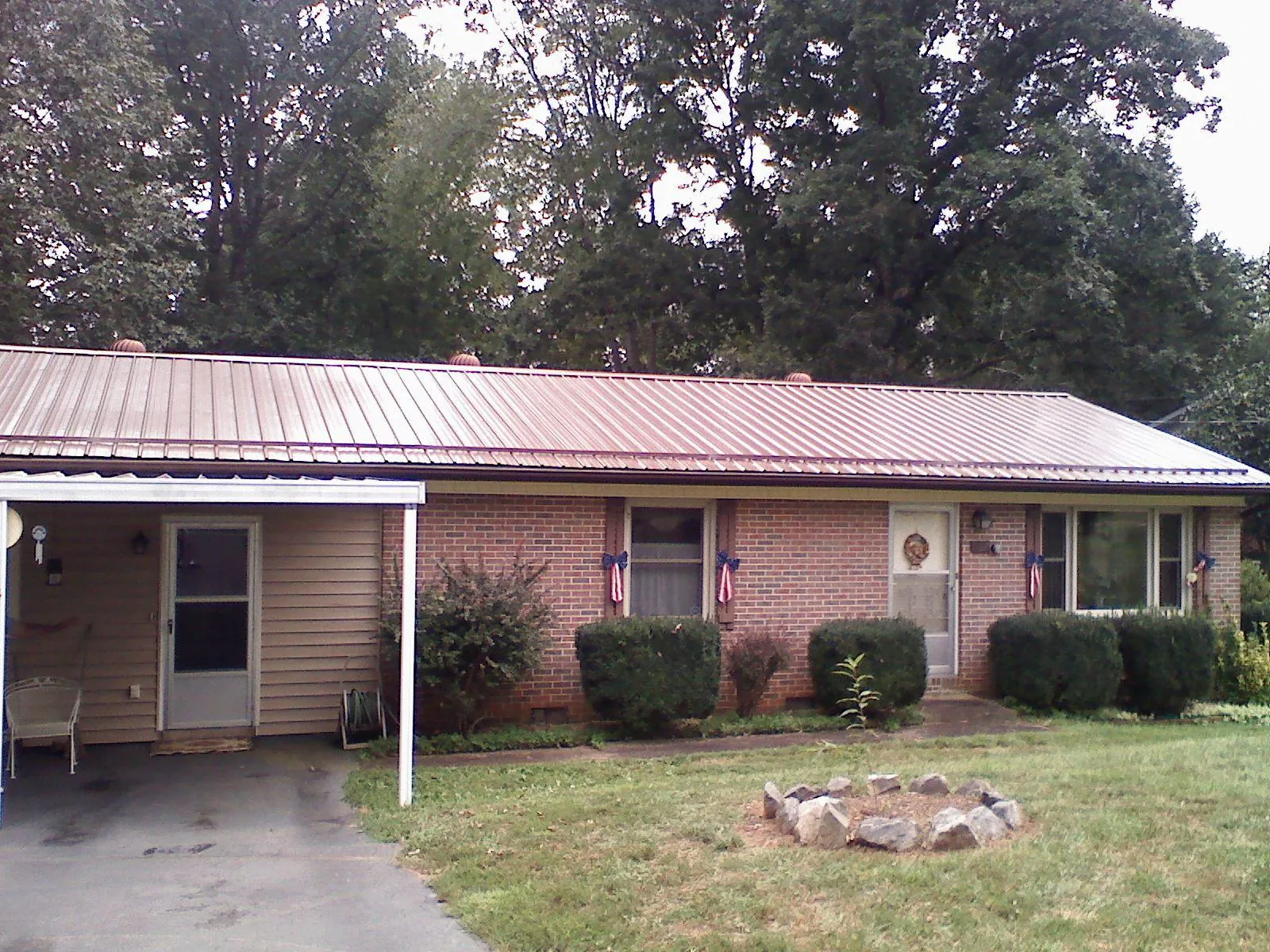 Bronze metal roof and carport on a brick ranch home — Roof Repair work by our crew in Bear Creek